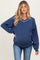 woman wearing a navy blue maternity sweatshirt with a v-neck and white collar detail, showing her baby bump