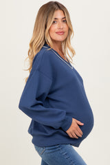 woman wearing a navy maternity sweatshirt with a v-neck and holding her baby bump