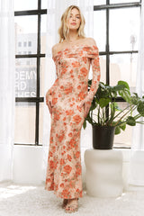 woman wearing a floral off-the-shoulder maxi dress with long sleeves and a fitted silhouette