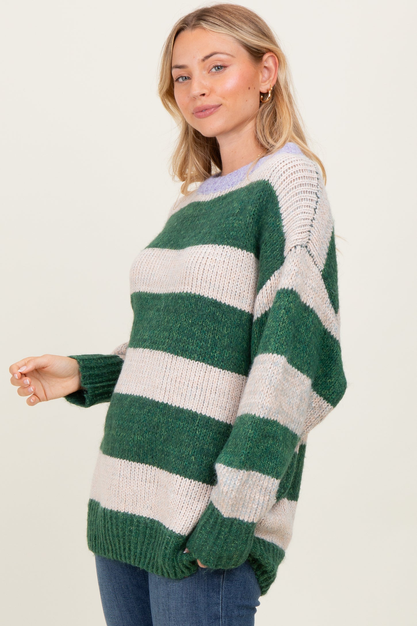 woman wearing a green and cream striped oversized sweater with relaxed fit and long sleeves