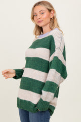 woman wearing a green and cream striped oversized sweater with relaxed fit and long sleeves