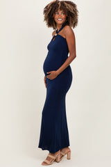 woman wearing a navy blue fitted maternity dress with a halter neck and a visible baby bump