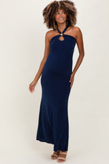 woman wearing a navy blue halter neck maternity dress with a keyhole detail and a flowy skirt, showcasing her baby bump