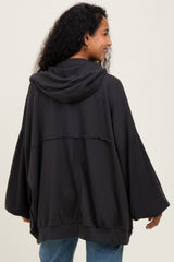 woman wearing a dark gray maternity hoodie with a relaxed fit and wide sleeves, showing off her baby bump from behind
