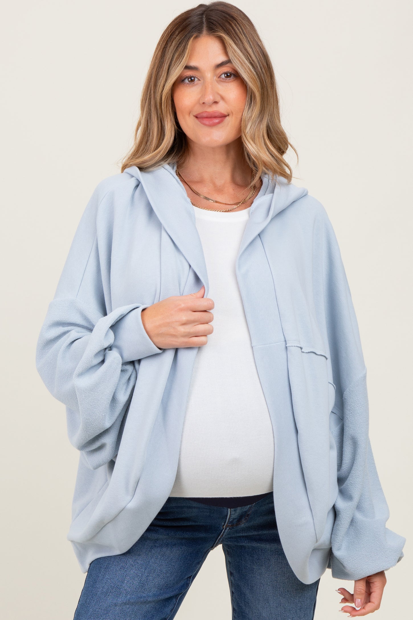 woman wearing a light blue maternity hoodie with a relaxed fit and a visible baby bump