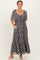 woman wearing a navy floral maxi dress with short flutter sleeves and pockets