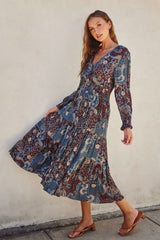 woman wearing a multicolored paisley print long sleeve maxi dress and brown heeled sandals