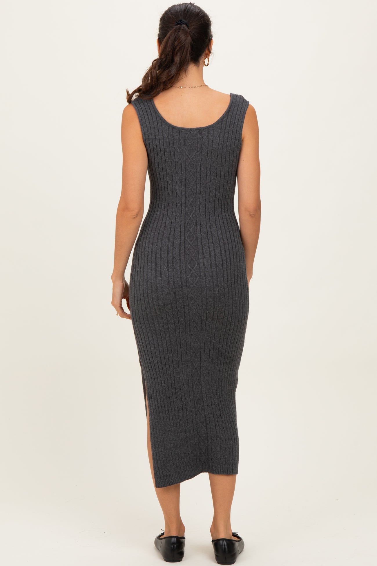 woman wearing a dark gray ribbed knit midi dress with a fitted silhouette and side slits