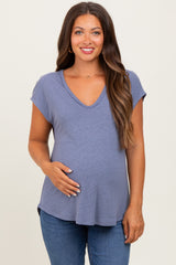 woman wearing a lavender maternity top with a v-neck and short sleeves, holding her baby bump