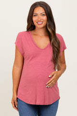 woman wearing a rose pink short sleeve maternity top and holding her baby bump