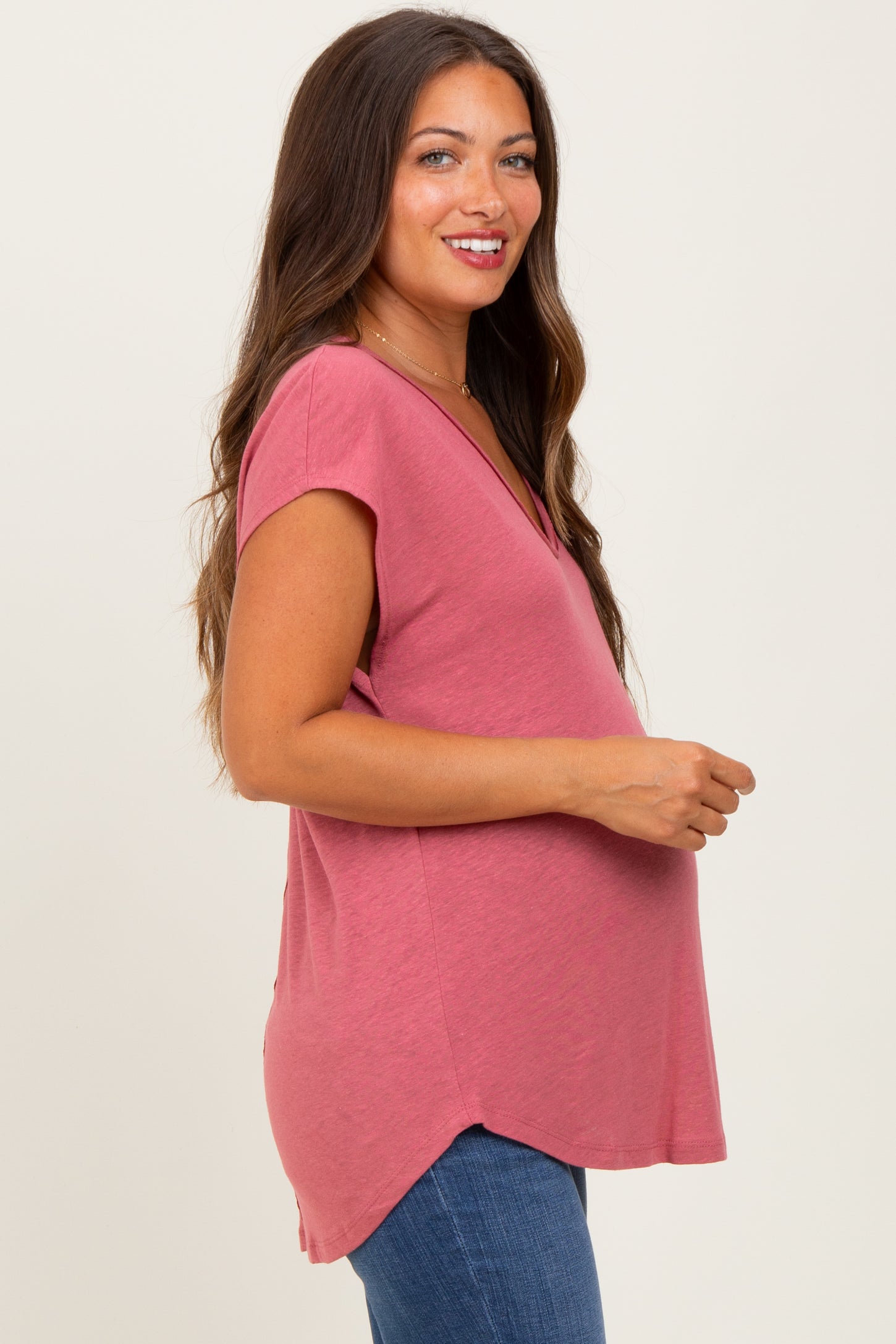 woman wearing a dusty rose maternity top with short sleeves and a v-neck, showing her baby bump