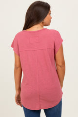 woman wearing a pink maternity top with short sleeves and a relaxed fit, standing with her back to the camera