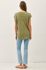 woman wearing an olive green short sleeve top with a back pocket and light blue skinny jeans