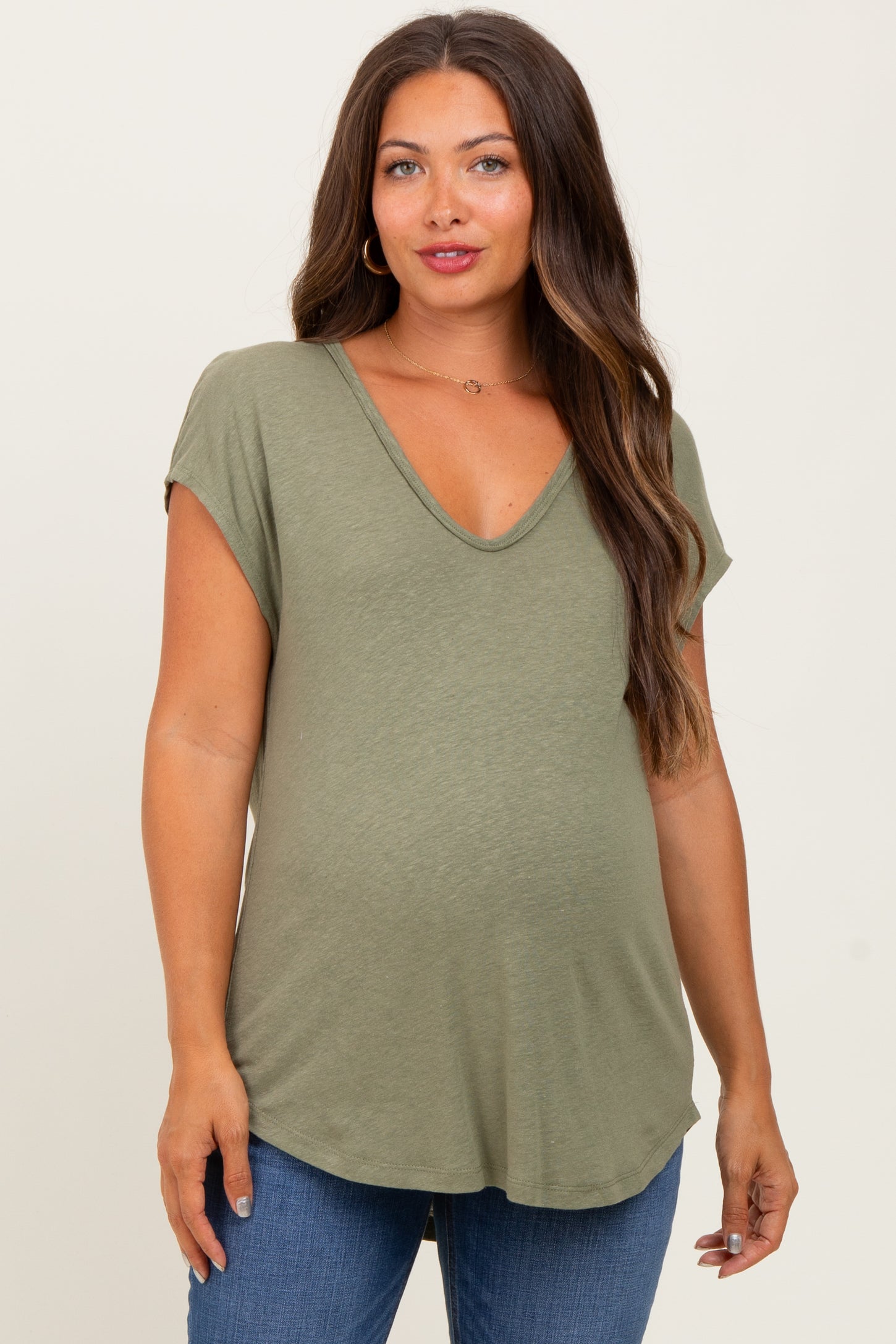 woman wearing a v-neck olive green maternity top with short sleeves and a baby bump visible