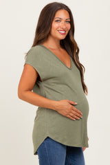 woman wearing a green maternity top with a v-neck and holding her baby bump