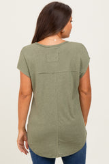 woman wearing a green short sleeve maternity top, showing the back and curved hem of the shirt