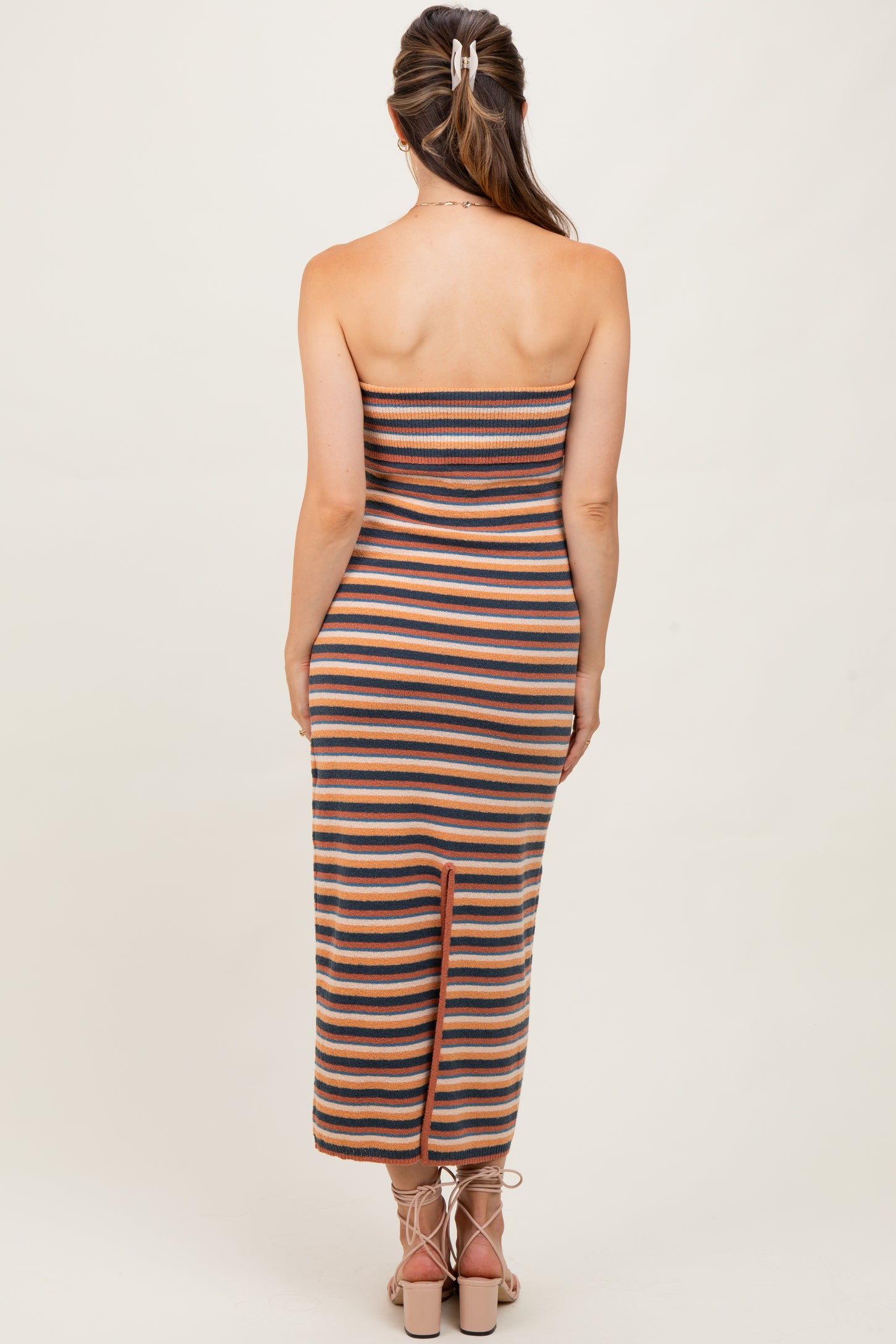 woman wearing a striped strapless maternity dress with a back slit