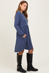 woman wearing a navy striped long sleeve dress with a flared skirt and pockets, paired with black knee-high boots