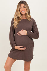 woman wearing a brown ribbed maternity dress and holding her baby bump