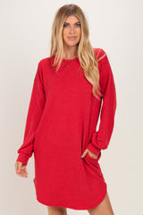 woman wearing a red ribbed long sleeve dress with a relaxed fit and side pockets
