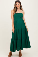 woman wearing a green tiered maternity maxi dress with spaghetti straps and a relaxed fit
