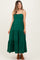 woman wearing a green maternity maxi dress with adjustable spaghetti straps and tiered ruffle details