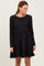 woman wearing a black long sleeve tiered dress with a textured fabric and round neckline