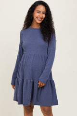 woman wearing a navy ribbed long sleeve maternity dress with a tiered skirt and a relaxed fit