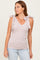 woman wearing a light pink striped tank top with tie straps and a v-neck, paired with light wash jeans