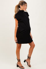 woman wearing a black maternity dress with a high neck and short sleeves, showing her baby bump