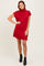 woman wearing a red short sleeve turtleneck dress and black ankle boots
