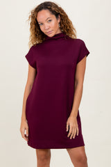 woman wearing a maroon short sleeve dress with a high neck and relaxed fit