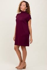 woman wearing a burgundy short sleeve mock neck dress and tan ankle boots