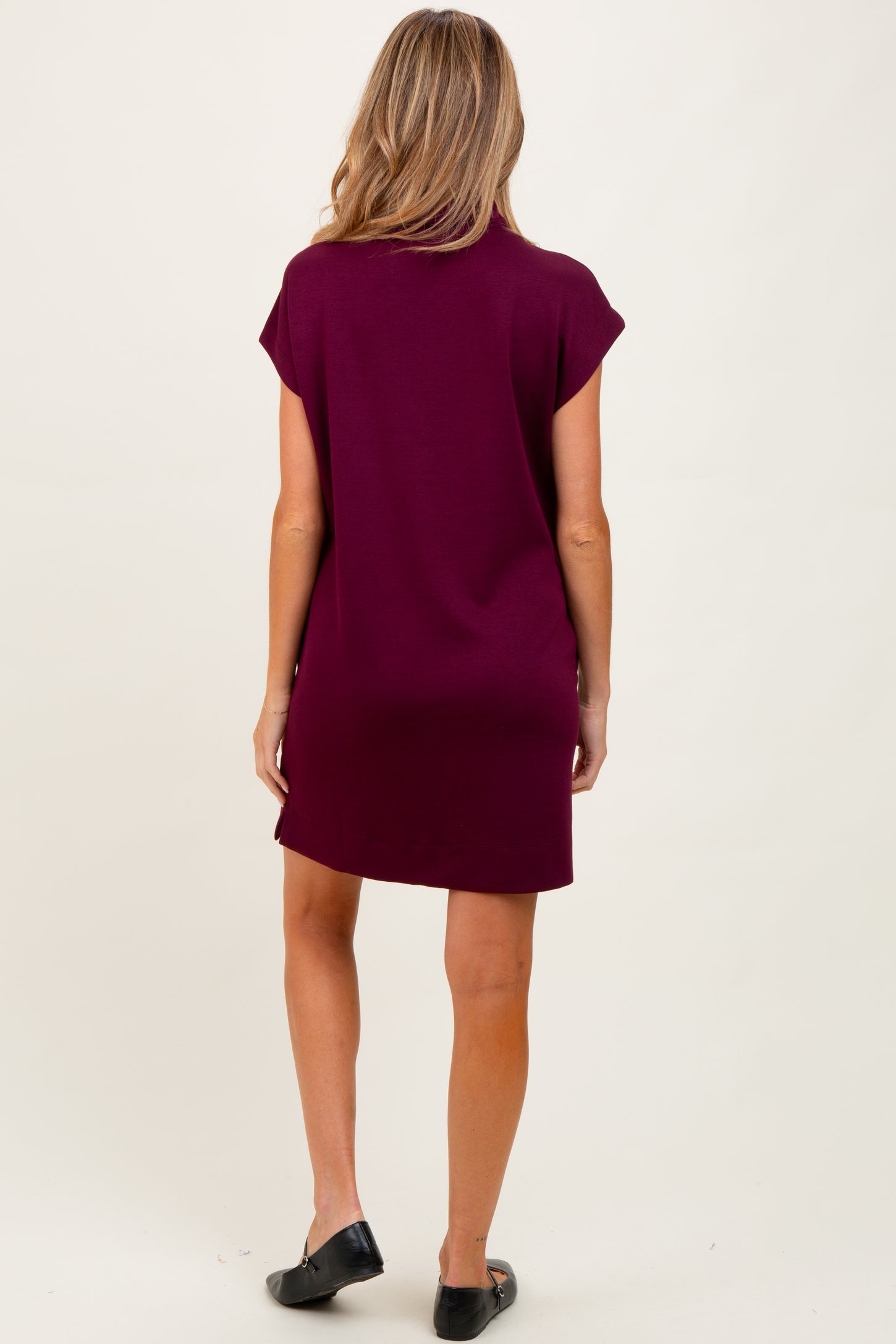 woman wearing a burgundy short sleeve maternity dress, viewed from the back, casual style