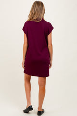 woman wearing a burgundy short sleeve maternity dress, viewed from the back, casual style