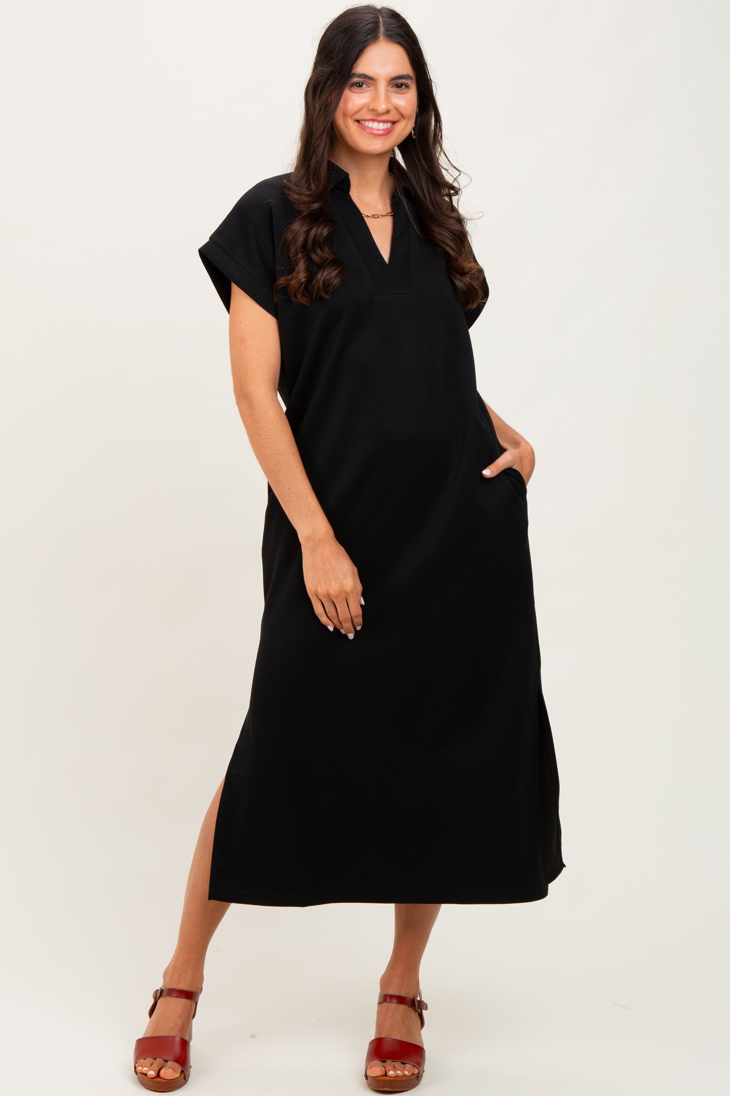 woman wearing a black short sleeve maxi dress with a v-neck and side pockets