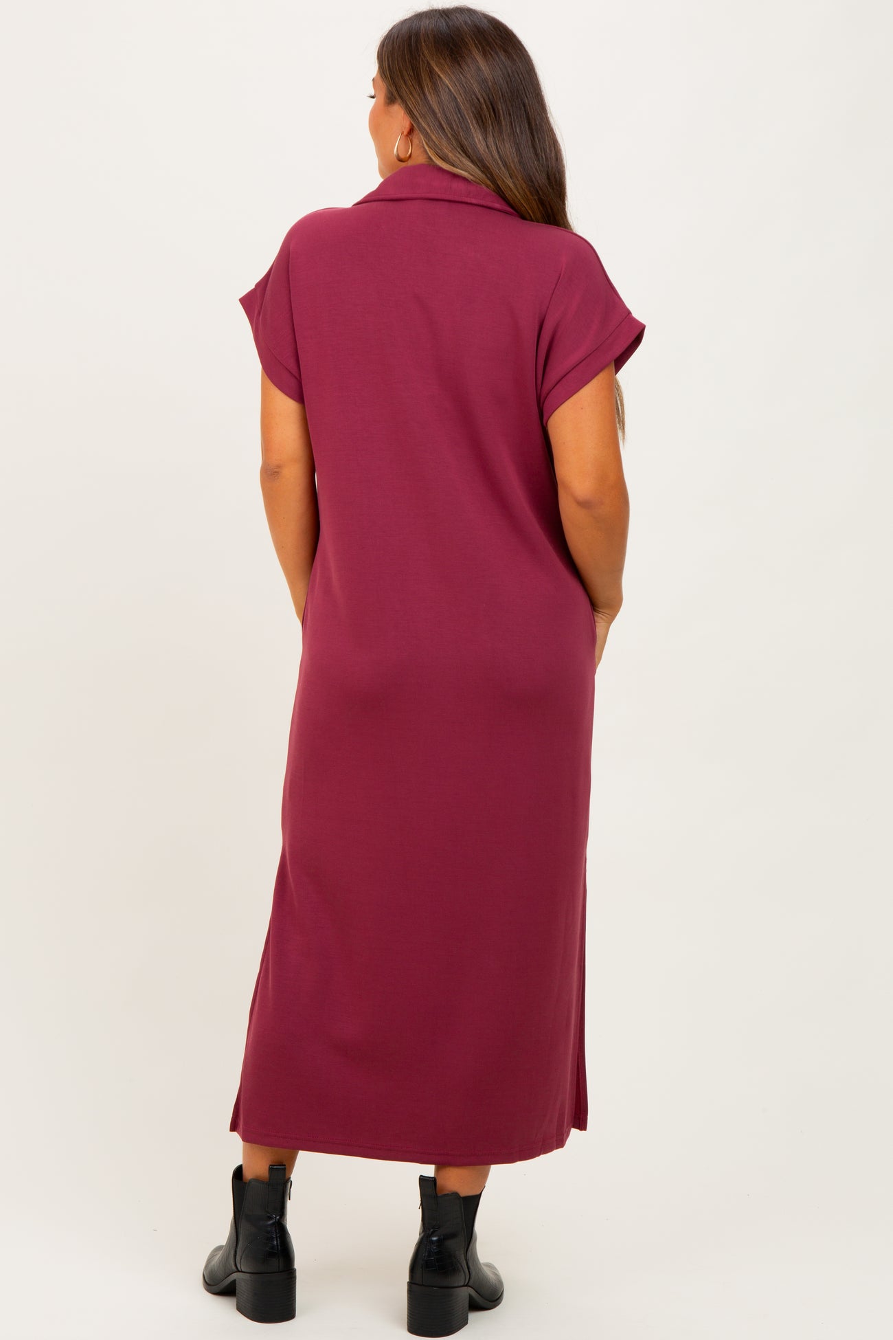 woman wearing a dark burgundy maternity maxi dress with short sleeves, shown from the back