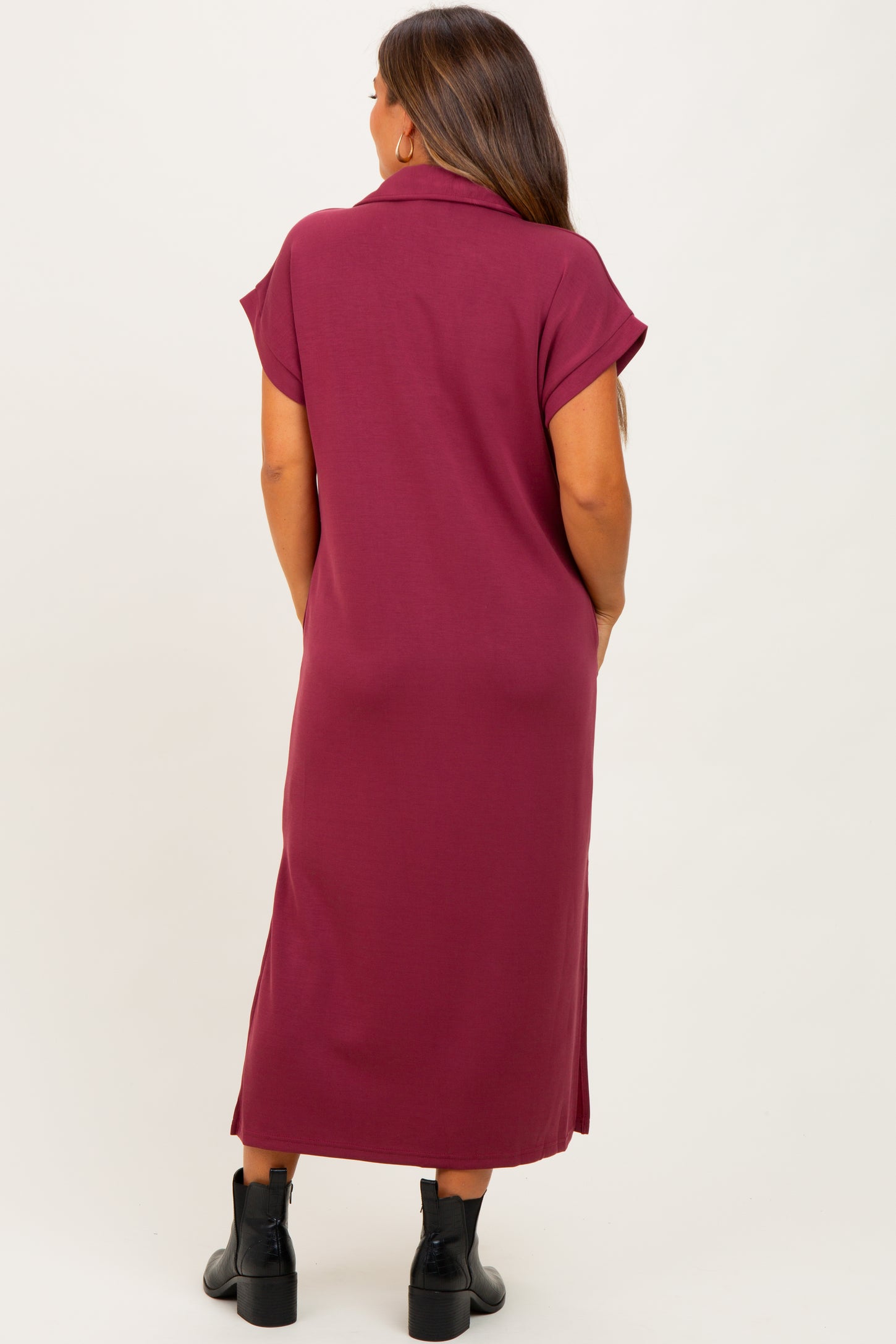 woman wearing a dark burgundy maternity maxi dress with short sleeves, shown from the back