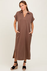 woman wearing a brown short sleeve maxi dress with a collar and side pockets, standing in wedge sandals