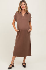 woman wearing a brown short sleeve maternity dress with pockets and side slits, holding her baby bump
