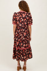 woman wearing a brown floral maxi dress with puff sleeves and red trim, viewed from the back