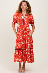woman wearing a red floral midi dress with puff sleeves and pockets, featuring a tiered skirt and a v-neckline