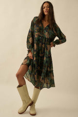 woman wearing a green floral long sleeve dress with a tiered skirt and tan knee-high boots