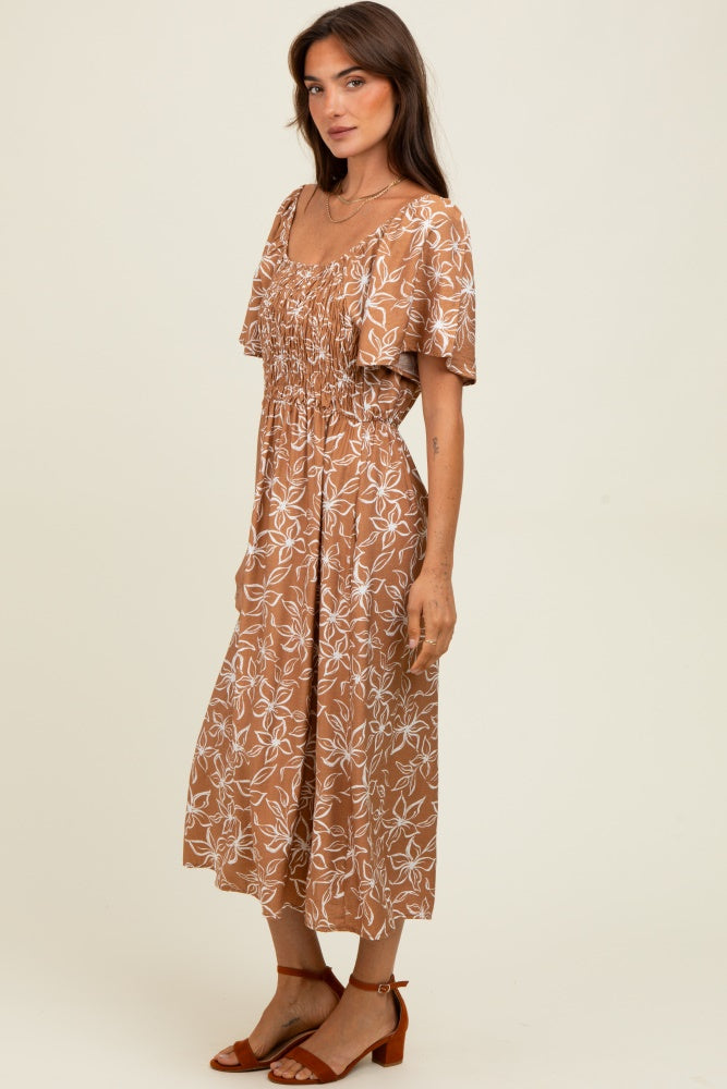 woman wearing a brown floral midi dress with a smocked bodice and short flutter sleeves