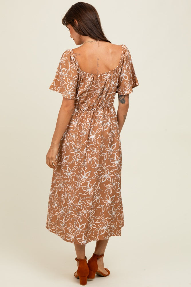 woman wearing a brown floral midi dress with short sleeves and a smocked back detail