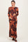 woman wearing a long sleeve floral print maternity dress with a form-fitting silhouette and holding her baby bump