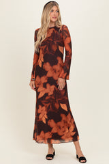 woman wearing a long sleeve dark floral maxi dress with warm tones and a flowy silhouette