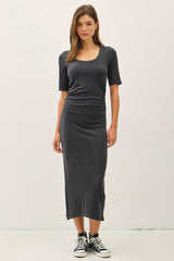 woman wearing a fitted charcoal gray midi dress with short sleeves and side slits, paired with black high-top sneakers