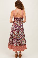 woman wearing a floral print maxi dress with a fitted bodice and tiered hem, showing the back view
