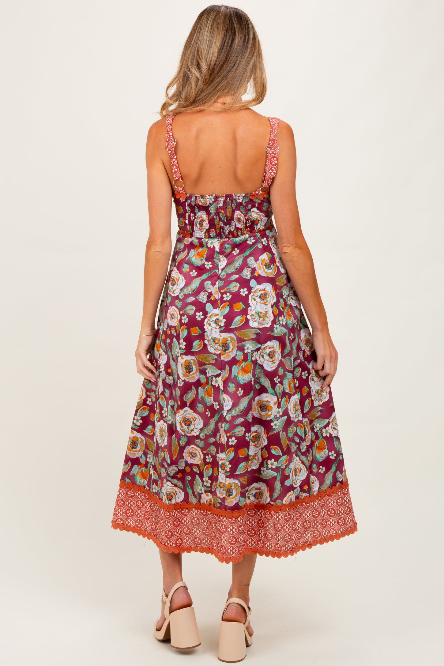 woman wearing a floral print maternity maxi dress with spaghetti straps and a detailed hemline, showing a relaxed fit